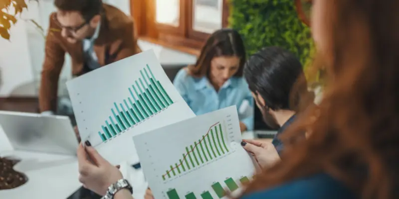 Teammeeting mit Fokus auf Wachstumsdiagramme – Auswertung von Geschäftszahlen und Strategien.